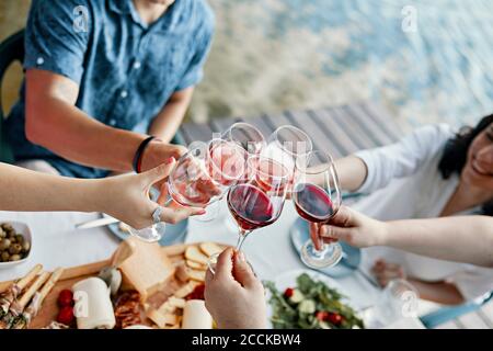 Des amis dînant dans un verre à vin de lac Banque D'Images