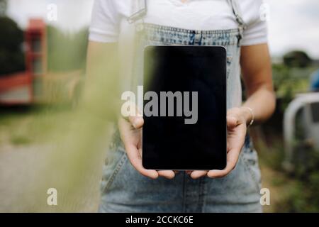 Femme affichant un écran de tablette vierge Banque D'Images