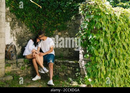 Jeune couple amoureux assis sur le banc, Bellagio, Italie Banque D'Images