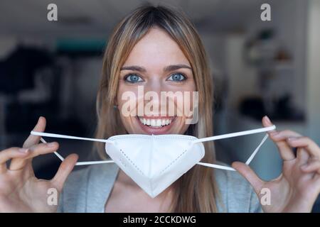 Portrait d'une jeune femme souriante portant un masque de protection Banque D'Images