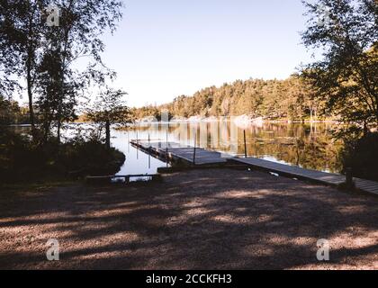 Promenade en bois ou jetée dans un lac près d'un lieu de baignade à s gothenburg suède , pas de personnes à cause de COVID Banque D'Images