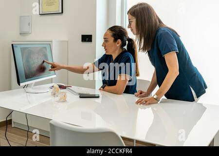 Les femmes médecins discutant en regardant la radiographie dans le cabinet du dentiste Banque D'Images