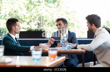 Les hommes d'affaires discutent lors d'une réunion au restaurant Banque D'Images