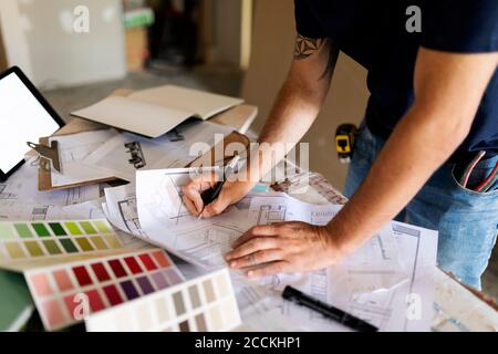 Homme travaillant sur le plan de construction et la nuance de couleur Banque D'Images