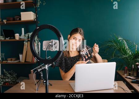 Jeune femme faisant un tutoriel vidéo de maquillage Banque D'Images