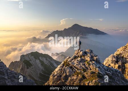 Randonneur admirant une vue magnifique en se tenant sur le sommet de la montagne aux Alpes de Bergamasque, Italie Banque D'Images