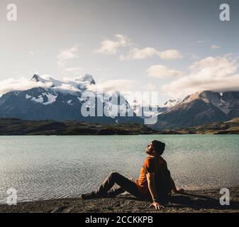 Homme relaxant au bord du lac Pehoe dans le parc national Torres Del Paine, Chili Patagonie, Amérique du Sud Banque D'Images
