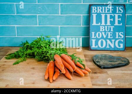 Carottes fraîches sur la planche à découper en cours de cuisine Banque D'Images