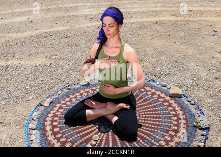 Femme pratiquant le yoga et méditant à la plage Banque D'Images