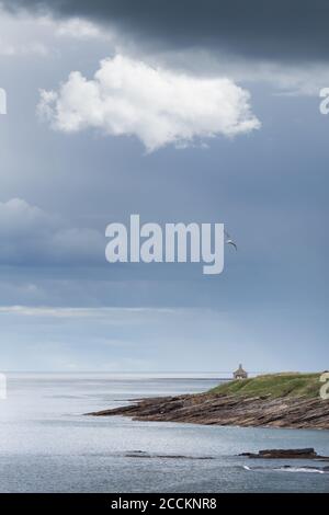 La maison de baignade à Howick sur la côte de Northumberland, une maison donnant sur la mer, lors d'une journée de tempête avec des nuages de pluie et un nuage blanc dérivant Banque D'Images