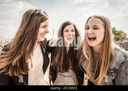 Trois amies adolescentes qui rient dehors Banque D'Images