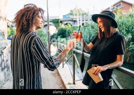 Couple heureux de déguster des boissons en se tenant sur la piste de marche du parc Banque D'Images