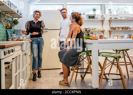 Chef expliquant les étudiants masculins et féminins lors d'un cours de cuisine Banque D'Images