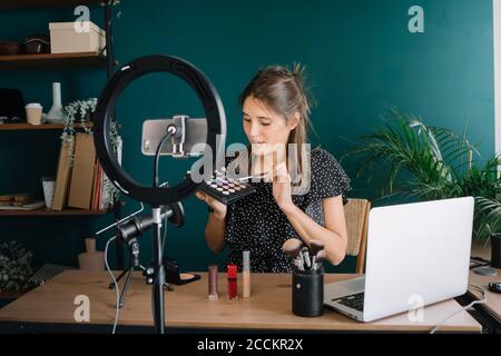 Jeune femme faisant un tutoriel vidéo de maquillage Banque D'Images