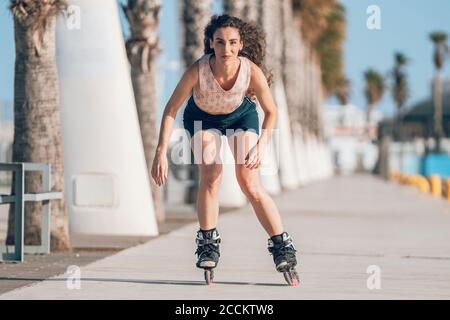 Jeune femme patineuse en ligne sur la promenade de la côte Banque D'Images