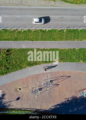 Russie, Tikhvin, Homme à vélo sur la piste près du parc de jeux, vue aérienne Banque D'Images