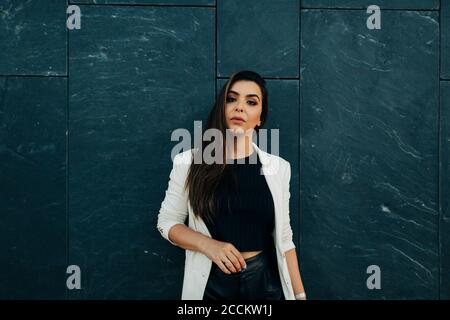 Portrait de la jeune femme devant le mur noir Banque D'Images
