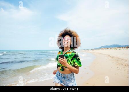 Happy young woman running at the beach Banque D'Images