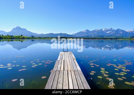 Jetée sur les rives du lac Hopfensee avec les montagnes de Tannheim arrière-plan Banque D'Images