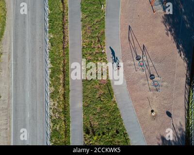 Russie, Tikhvin, Homme à vélo sur la piste près du parc de jeux, vue aérienne Banque D'Images