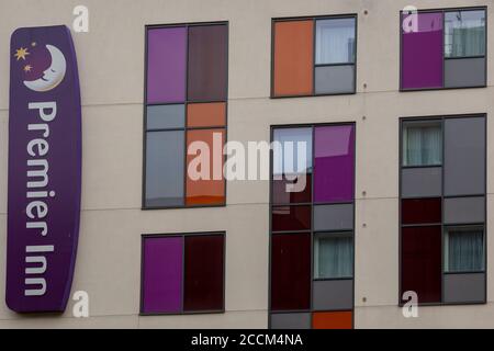 Un panneau d'hôtel Premier inn et des fenêtres colorées sur le côté d'un hôtel haut de gamme Banque D'Images