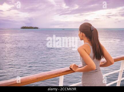 Luxueuse croisière femme de vacances regardant le paysage exotique de Tahiti depuis le pont du bateau au coucher du soleil. Élégante jeune fille touristique se détendre en vue sur l'océan Banque D'Images