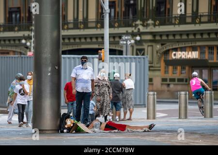 22 août 2020 : un homme sans domicile dort devant le terminal du ferry de Staten Island alors que des piétons se promeuvent devant des masques EPI pour se protéger de Covid-19 à Manhattan, New York. Crédit obligatoire : Kostas Lymperopoulos/CSM Banque D'Images