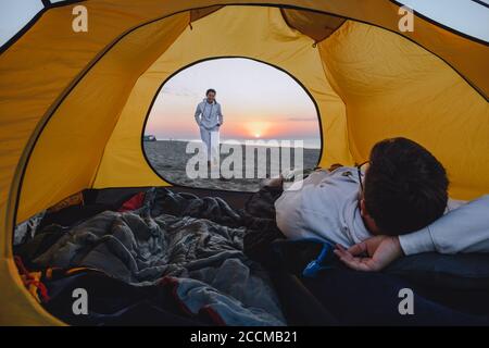 couple dormant dans une tente de camping avec vue sur le lever du soleil Banque D'Images