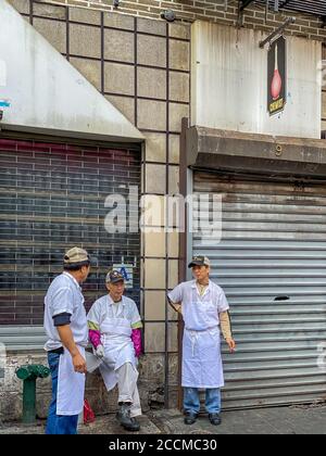 NEW YORK CITY, ÉTATS-UNIS - 27 décembre 2019 : les chefs font une pause-fumée à Doyers Street, Chinatown, New York City Banque D'Images