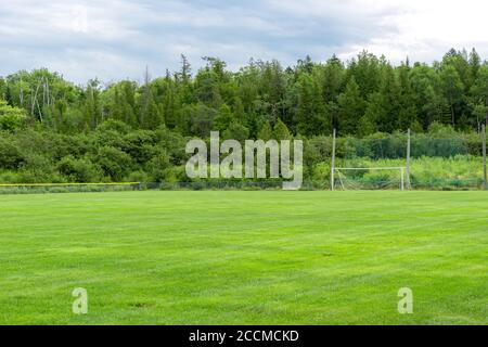 Un terrain de football vide sous un ciel couvert. L'herbe est bien entretenue, et un filet d'objectif est dans la distance. Banque D'Images