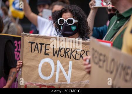 Manifestant féminin, portant des lunettes de soleil et un masque facial tenant un travailleur de la grève bannière à l'extérieur de la moderne de la Tate. Londres, Royaume-Uni Banque D'Images
