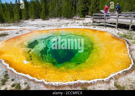 Yellowstone National Park, Wyoming / USA - 22 juillet 2014: Morning Glory Pool avec des touristes sur une promenade regardant un panneau d'information aux jaunes Banque D'Images