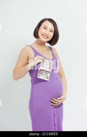 Femmes enceintes avec des images de film, femme enceinte asiatique montrer avec bébé à ultrasons sur fond blanc Banque D'Images