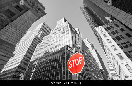 Stop rouge avec des bâtiments noirs et blancs en arrière-plan, focus sélectif, New York City, Etats-Unis. Banque D'Images