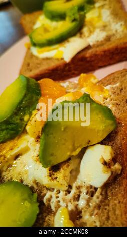 Plan vertical de toasts recouvert d'oeuf et d'avocat pour petit déjeuner Banque D'Images