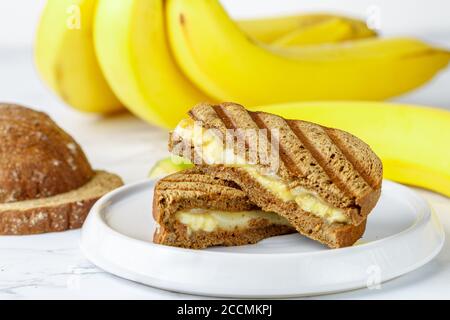 Sandwich au pain de seigle grillé avec banane et fromage à la crème. Délicieux petit déjeuner sain pour adultes et enfants. Mise au point sélective Banque D'Images