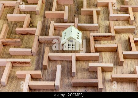 concept immobilier, modèle de labyrinthe en bois avec maison dans le centre Banque D'Images
