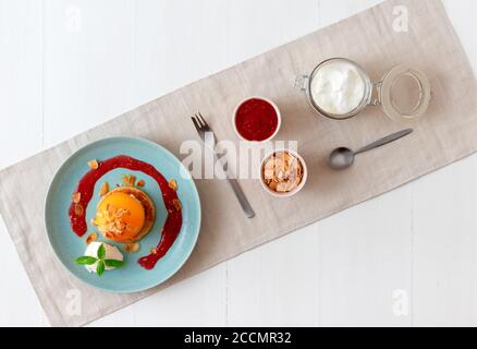 Pêches rôties avec crème fraîche au citron, citron vert et basilic et coulis de framboises. Délicieux dessert aux fruits doux, le Gordon Ramsey. Vue de dessus, woode blanc Banque D'Images