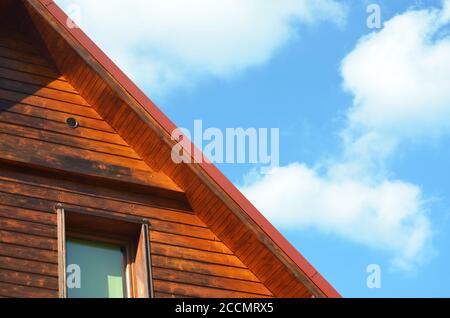 Pièce de façade de maison en bois avec fenêtre et toit incliné sur le fond bleu du ciel Banque D'Images