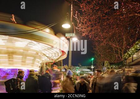 Foule de gens, illuminez les étals et le carrousel pendant Weihnachtsmarkt, marché de Noël à Heumarkt, célèbre place du marché de Noël à Cologne. Banque D'Images