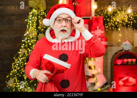 Thème vacances de Noël et nouvel an d'hiver. Hommes en vêtements d'hiver. Joyeux Père Noël habillé de vêtements d'hiver pensez à Noël près de l'arbre de Noël. Banque D'Images