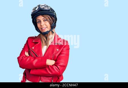 Jeune belle femme portant un casque de moto visage heureux souriant avec des bras croisés regardant la caméra. Personne positive. Banque D'Images