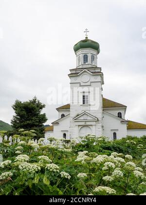 Des fleurs entourent l'église de la Sainte Ascension dans la communauté d'Unalaska, en Alaska. Banque D'Images