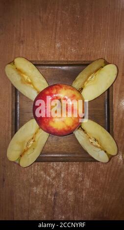 une pomme entière et des tranches de pomme sur un carré en bois vue de dessus de la plaque Banque D'Images