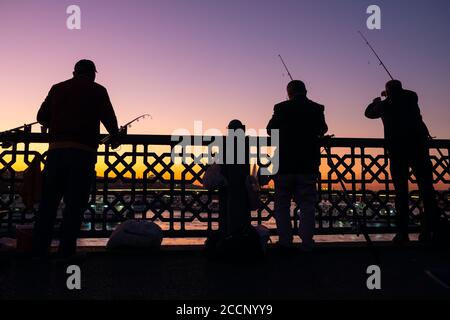 Pêcheurs turcs non identifiés sur le pont de Galata au crépuscule à Istanbul Banque D'Images