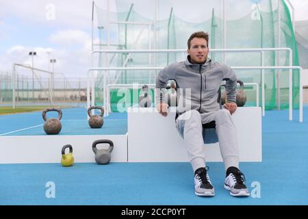 Gym fitness homme entraînement bras muscles faire des triceps trempettes au centre d'entraînement en plein air au stade. Athlète sportif en pantalon de sport vêtements de sport à l'extérieur Banque D'Images