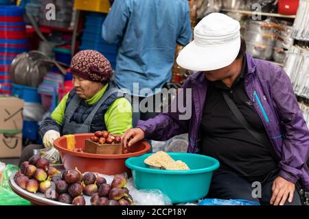 Séoul, Corée du Sud; octobre 2019: Deux femmes âgées qui vendent de la nourriture sur un marché de rue. Ils vendent des fruits et des figues d'automne. Port de chapeaux. Séoul, Corée Banque D'Images