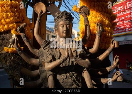 La statue d'une déesse de type hindou taoïste multi-armée, illuminée par la lumière du matin, debout à Bamrung Muang Rd., Bangkok, Thaïlande Banque D'Images