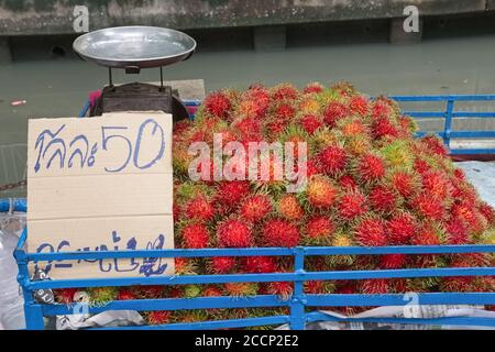 Une charrette de vendeur de rue à Bangkok, en Thaïlande, avec des rambutans (Nephelium lapaceum), un fruit originaire de l'Asie du Sud-est; le panneau de prix indique 50 Baht/kilo Banque D'Images