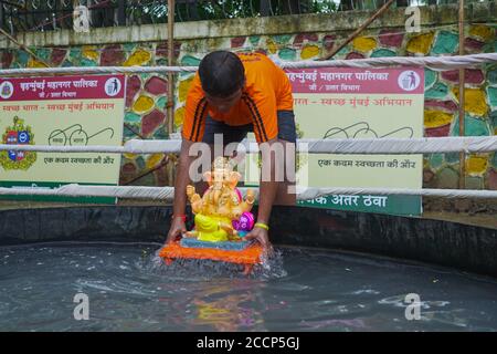 Ganesh idol immersion dans les restrictions de la pandémie de covid 19. Ganpati Visarjan en Homme fait des gens d'étang avec masque -Mumbai, Maharashtra / Inde. Banque D'Images